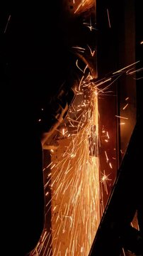 An intense moment of steel cutting in heavy industry, where sparks fly as precision meets power in the manufacturing process. Heavy industrial, iron cutting process. Worker cutting iron