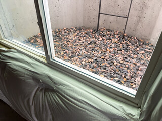 Concrete Basement Window Well with Ladder and Stones