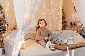 Little boy playing with a toy. Child is sad sitting on the bed.