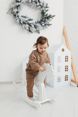 little boy playing with a toy house