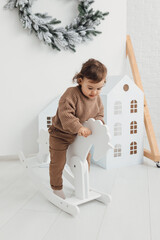 Little boy playing with toy horse. Child swinging on a rocking horse on a white background
