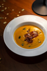 Gourmet pumpkin cream soup with elegant plating in restaurant
