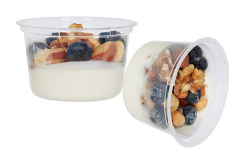 Thick white yogurt topped with a mixture of fresh blueberries, pecans and other nuts cut out...
