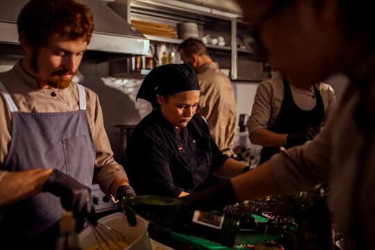 Adult chefs focused on food prep in busy restaurant kitchen
