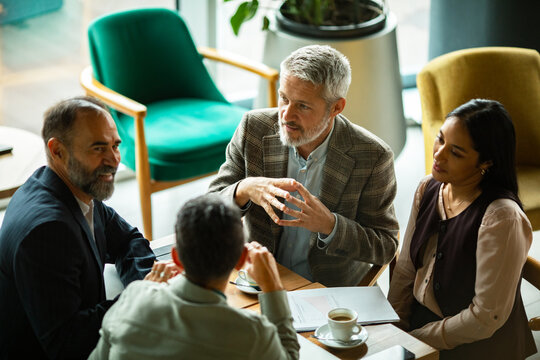 Adult coworkers in focused discussion at cafe table