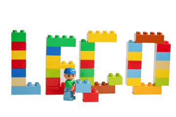 Naklejka premium A Lego minifigure with toy bricks in front of the word 
