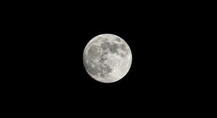 Obraz premium Image of a full moon against a black background, revealing its cratered surface, representing lunar cycles, astronomy, or nocturnal exploration