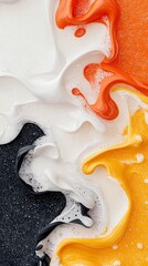 A close-up abstract view of swirling liquids in orange, yellow, and white, with bubbles and textures, against a dark speckled background.