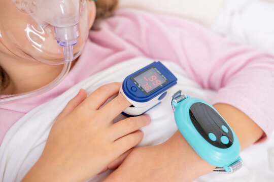 Young person, girl receiving oxygen therapy, Child lies with oxygen mask and pulse oximeter on finger, patient health tracker, pediatric respiratory care, recovery hospitalization, health monitoring - Powered by Adobe