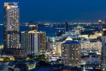 Fototapeta premium The high angle background of the city view with the secret light of the evening, blurring of night lights, showing the distribution of condominiums, dense homes in the capital community