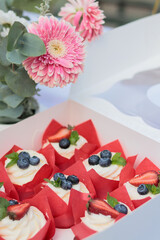 table setting with flowers and cupcakes with creamcheese and blueberries closeup 