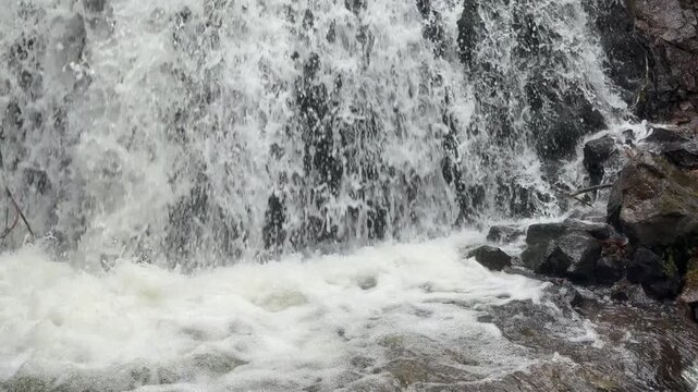 Water rushing down a river in slow motion in Wales in winter rainfall. Nature in the winter England UK 4K