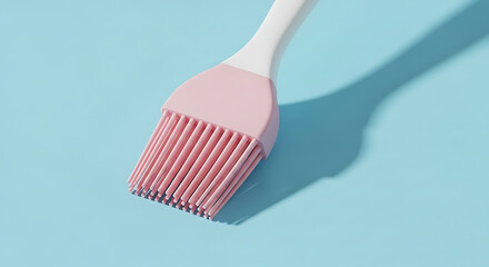 A pastel pink silicone basting brush with a white handle on a light blue background casting a shadow