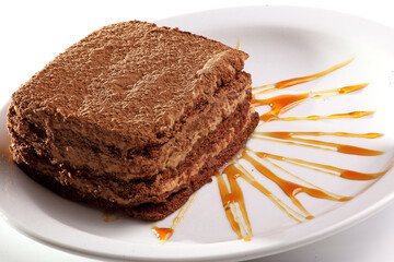 Close up of chocolate cake with cocoa powder, cream and syrup