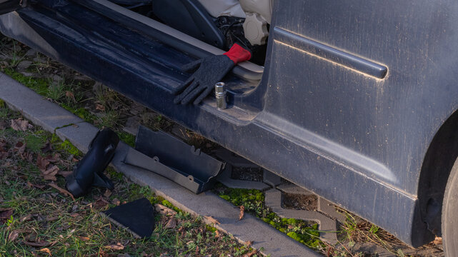 Car door open with repair tools and glove on ground outdoor scene