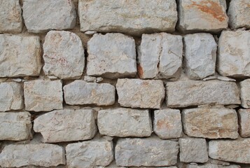 High-resolution close-up of a stacked stone wall showing rough, natural textures, irregular shapes, and earthy tones—ideal for backgrounds, architectural design, construction materials, and texture