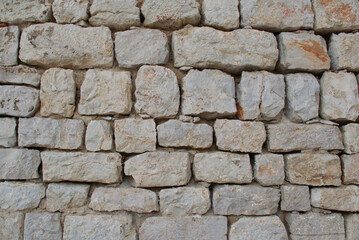 High-resolution close-up of a stacked stone wall showing rough, natural textures, irregular shapes, and earthy tones—ideal for backgrounds, architectural design, construction materials, and texture