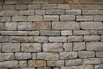 High-resolution close-up of a stacked stone wall showing rough, natural textures, irregular shapes, and earthy tones—ideal for backgrounds, architectural design, construction materials, and texture