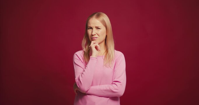 Pensive worry blonde woman thinking and worry looking away having trouble on red background