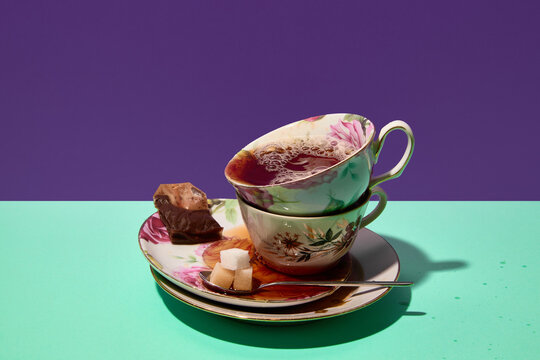 Stacked floral teacups with tea sugar cubes and chocolate. Concept of packaging, tableware marketing, menu illustrations, tea advertising, and magazine content. - Powered by Adobe