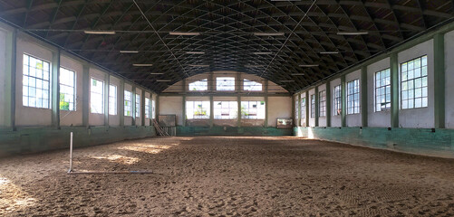 Covered arena building interior without people ready for equestrian training. Place to train horses