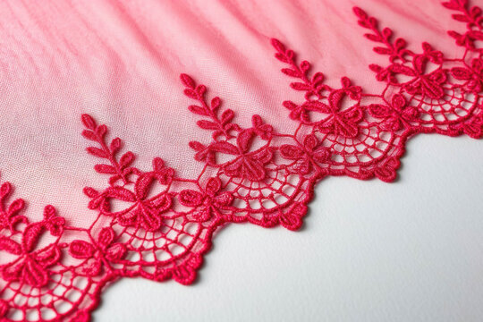 Hot pink or raspberry lace on translucent tulle fabric, floral pattern, top view on a white background