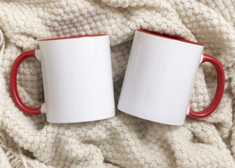 White accented coffee mugs with red handle on beige plaid top view, boho mockup