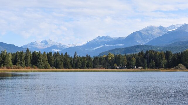 Rainbow Park, Whistler, British Columbia, Canada: the trail and park along Rainbow Lake on a good weather day with blue sky and reflection of trees - Powered by Adobe