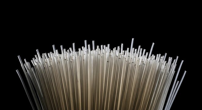 A dramatic close-up of a bundle of translucent fiber optic cables glowing with transmitted light, creating an abstract technological pattern against a solid black background