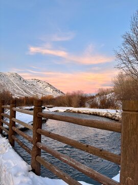 Winter sunset from a wooden bridge over a stream in the mountains