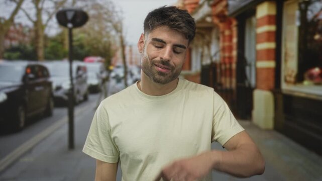 Man with beard smiling under lamppost on city street with parked car and building facade in color; confidence charisma.