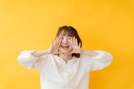 黄色い背景で呼びかける女性