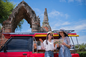 Tourists enjoying a tuk-tuk ride at ancient temple ruins in Thailand
