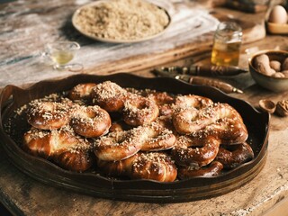 Warm Romanian mucenici are beautifully arranged on a wooden tray, topped with crushed nuts