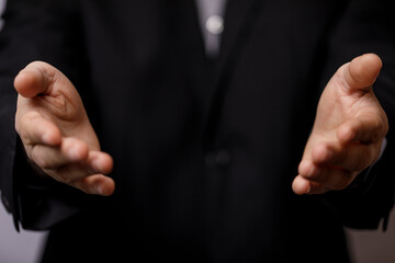 Business person holding out hands. Gesture of openness, welcoming, sharing, asking, or receiving....