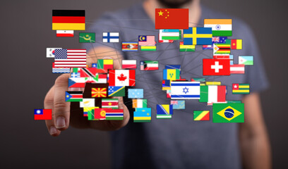 Concept of global communication and interconnectedness illustrated with a hand touching flags of...