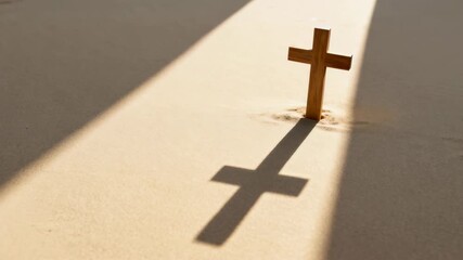 A wooden cross stands in the sand casting a long shadow in a beam of light. Vertical video of a christian symbol representing faith and hope. Easter and resurrection concept - Powered by Adobe