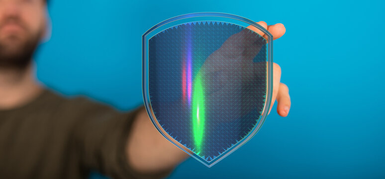 A person holding a shield with a glowing effect symbolizes digital security, data protection, and a sense of safety. Perfect for cybe