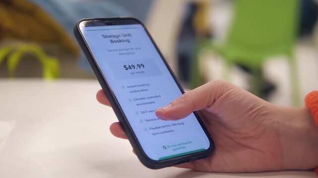 Closeup of a womans hands in a public space effortlessly activating a new eSIM plan on her smartphone. After reviewing the terms and price, she confirms the purchase, receiving instant activation