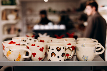 Handmade printed cups on store shelf for gift idea concept.