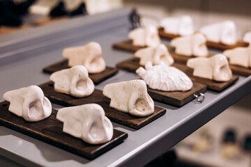 Ceramic anatomical sculptures displayed on wooden stands.