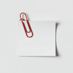 A single red paperclip holds a white square sticky note isolated on white background