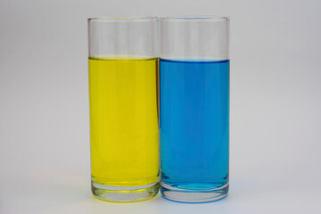 The photo shows two glasses with different colored drinks.
