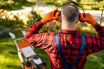 Landscaper touching hearing protection gear posing backwards
