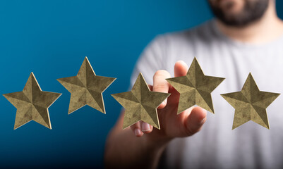 A hand reaching towards golden stars, symbolizing reviews, rating, feedback, and success. Perfect for illustrating positive experiences and cust