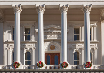 The neoclassical California State Capitol Building at Christmas time, wreaths on each white pillar, in downtown Sacramento