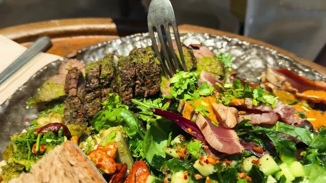 Grilled beef with sauce pesto, spinach and kale salad on a plate close-up. Healthy food. High quality 4k footage