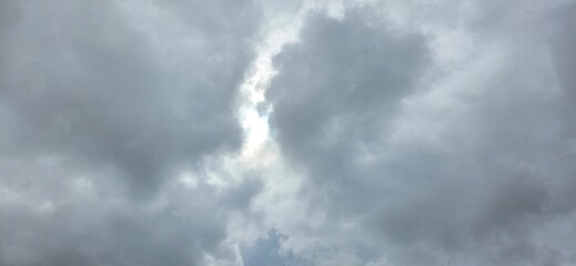 A sky filled with heavy clouds, pierced by a bright light at the center. This striking contrast evokes hope breaking through even the greyest days.