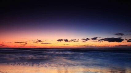 an aerial shot of a landscape and sky , taken from an airplane window during sunset