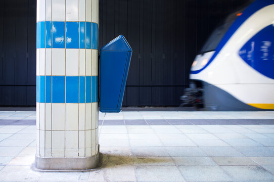 Waste bin on a platform pillar in a railway station.